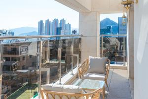 balkon z krzesłami i widokiem na miasto w obiekcie Asherah Villa d' aqua Hotel w mieście Gimhae