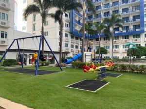 une aire de jeux dans un parc en face d'un bâtiment dans l'établissement Sea Residences by EXIN, à Manille