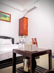 1 dormitorio con 1 cama y 1 mesa con botellas de agua en Trường Yến Hotel Ninh Bình en Ninh Binh
