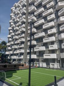 um edifício com um campo de ténis em frente em Hermoso Apartamento en zona exclusiva em Armênia