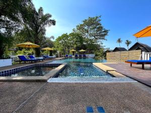 a swimming pool with chairs and umbrellas in a resort at Treeya Lanta in Ko Lanta