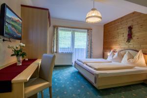 ein Hotelzimmer mit einem Bett und einem Schreibtisch in der Unterkunft Gasthof zum Kaiserweg in Schladming