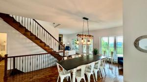 a dining room and living room with a table and chairs at Chalet Horizon Alpin Spa et Vue sur le Fleuve in Les Éboulements