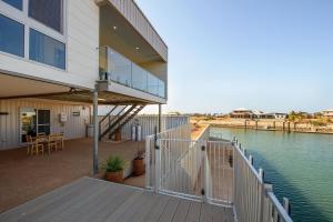 a house with a deck with a view of the water at 22 Cooyou Close in Exmouth