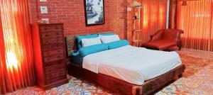 una camera con letto e parete di mattoni rossi di Mar's Joglo a Yogyakarta