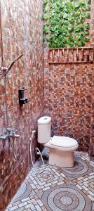 bagno con servizi igienici e muro di mattoni di Mar's Joglo a Yogyakarta