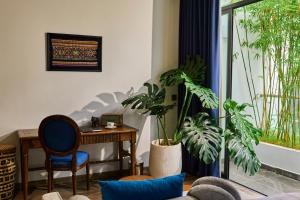 a living room with a table and some plants at The Coffee City - Healing & Retreats in Buon Ma Thuot