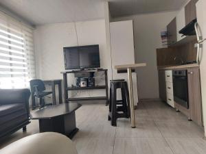 a living room with a flat screen tv and a kitchen at Apartaestudio3 Sector Cable-Estadio Mejor Ubicacion de Manizales in Manizales