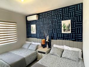 1 dormitorio con 2 camas y pared azul en El Depa de las Flores-300 m from the main blvd, en San Carlos