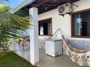 a house with a hammock and a heater on a porch at Casa Jubarte in Alcobaça