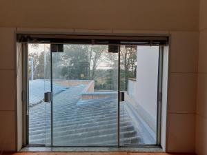 eine offene Glastür in einem Zimmer mit Treppe in der Unterkunft Sobrado com Suíte Master em Capitólio Furnas MG in São José da Barra