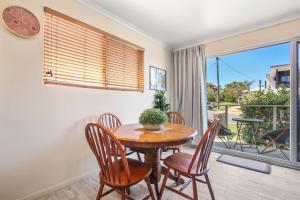 ein Esszimmer mit einem Tisch und Stühlen sowie einem Balkon in der Unterkunft Rosalie Unit 1, 4 Margaret St, Kings Beach in Caloundra