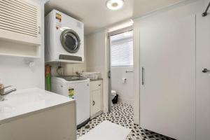 eine Küche mit Spüle und Waschmaschine in der Unterkunft Rosalie Unit 1, 4 Margaret St, Kings Beach in Caloundra