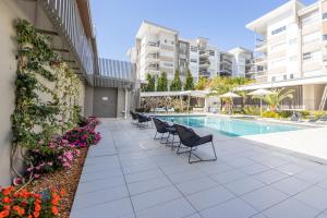 a patio with chairs and flowers next to a swimming pool at Boulevard North Lakes in North Lakes