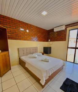 a bedroom with a bed and a brick wall at Felicità Praia Hotel in Fortaleza