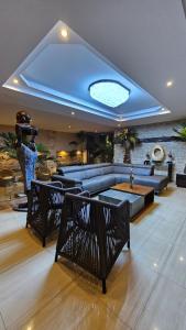 sala de estar con sofá y techo azul en Hotel & Suites Country, en Valladolid