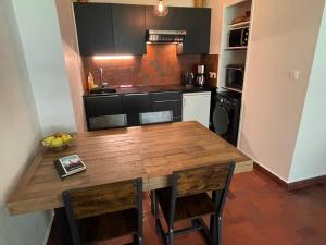 - une cuisine avec une table en bois et des chaises dans l'établissement Résidence Bois du Bouchet, appartement vue montagne, calme, parking gratuit, proche centre, à Chamonix-Mont-Blanc