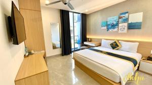 ein Hotelzimmer mit einem Bett und einem TV in der Unterkunft Aloha Hotel Vung Tau in Vũng Tàu