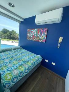 a bedroom with a bed and a blue wall at Piscina Mar en el Paraíso Caribe in Colón