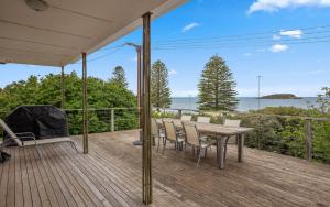 een terras met een tafel en stoelen en uitzicht op de oceaan bij Breathtaking Views of Encounter Bay Pet Friendly in Encounter Bay