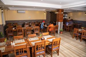uma sala de jantar com mesas e cadeiras de madeira em Hotel Hidden Kingdom em Pokhara