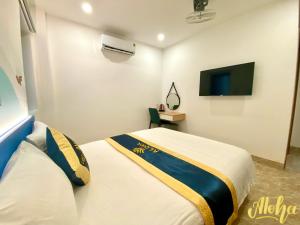 ein Hotelzimmer mit einem Bett und einem TV in der Unterkunft Aloha Hotel Vung Tau in Vũng Tàu