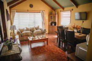 Una sala de estar con un sofá, una mesa y sillas. en Hostal Cordillera, en Punta Arenas