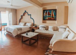 sala de estar con cama y sofá en Villa del Pescador, en Zihuatanejo