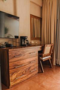 a large wooden dresser with a chair in a room at Villa del Pescador in Zihuatanejo