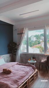 a bedroom with a bed and a large window at Hằng Nga Villa in Da Lat