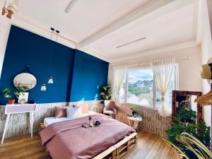 1 dormitorio con paredes azules y 1 cama grande en Hằng Nga Villa, en Da Lat