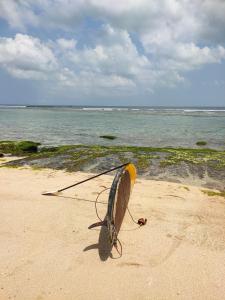 a surfboard sitting on the sand on the beach at Ulunia in Uluwatu