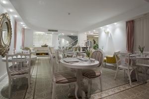 un comedor con mesas y sillas blancas en Cella Hotel & SPA Ephesus, en Selçuk