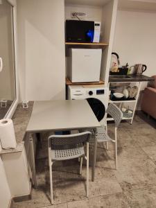 a kitchen with a white table and two chairs at Apartment hotels parking akaciju1 in Vilnius