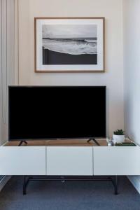 uma grande televisão de ecrã plano numa sala de estar em Easy Access to Chapel Street from this Sleek Stay em Melbourne