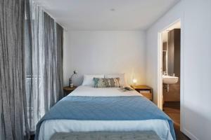 um quarto com uma cama azul e uma janela em Easy Access to Chapel Street from this Sleek Stay em Melbourne