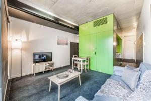 een woonkamer met een bank en een tafel bij Vibrant Inner-City Living with Luxe Rooftop Pool in Melbourne