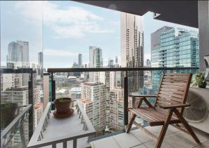 een stoel op een balkon met uitzicht op de stad bij Cradle the Clouds - Southbank Stay with Parking in Melbourne