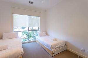 a bedroom with two beds and a window at Leafy Family Home with Outdoor Dining near CBD in Maribyrnong