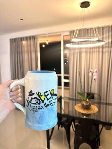 a person holding a coffee cup with graffiti on it at Loft proximo a Villa Germânica in Blumenau
