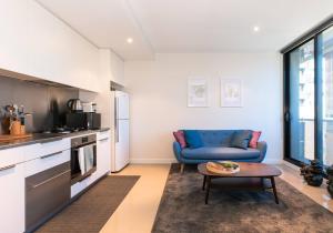 ein Wohnzimmer mit einem blauen Sofa und einem Tisch in der Unterkunft Elevated Elegance in the City's Chic Paris End in Melbourne