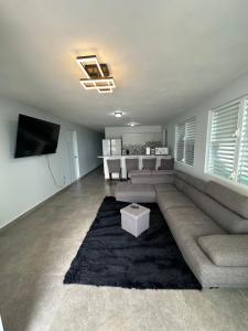 uma sala de estar com um sofá de secção e uma mesa em Black Pearl em Guayama