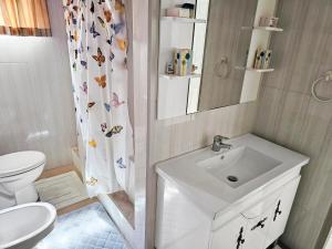 a bathroom with a sink and a toilet and a shower curtain at The Green Palms Getaway, Palmiste, San Fernando - 6 BR 4 Bath 12 guests 