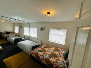 a bedroom with two beds and a mirror at Liberty Inn Room with sharing toilet and kitchen in Liverpool