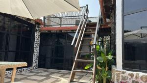 a ladder on the side of a house with an umbrella at CASA MARA Casa Rural con terraza, barbacoa y vistas al Teide in Tanque