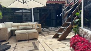 a patio with a chair and an umbrella and stairs at CASA MARA Casa Rural con terraza, barbacoa y vistas al Teide in Tanque