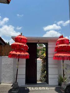 two red umbrellas in front of a building at Pererenan nengah guest house in Canggu