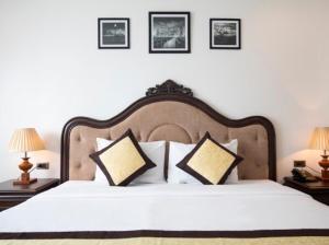 a bedroom with a large white bed with two lamps at NAM SON HOTEL in Ha Long