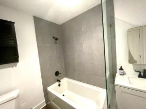 een badkamer met een bad, een wastafel en een douche bij Modern Gem 2 miles from Sofi in Los Angeles