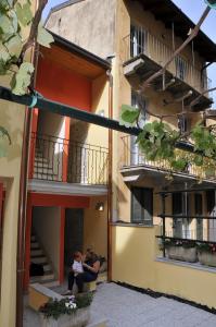 a woman and child sitting outside of a building at La Corte Fiorita Como in Como